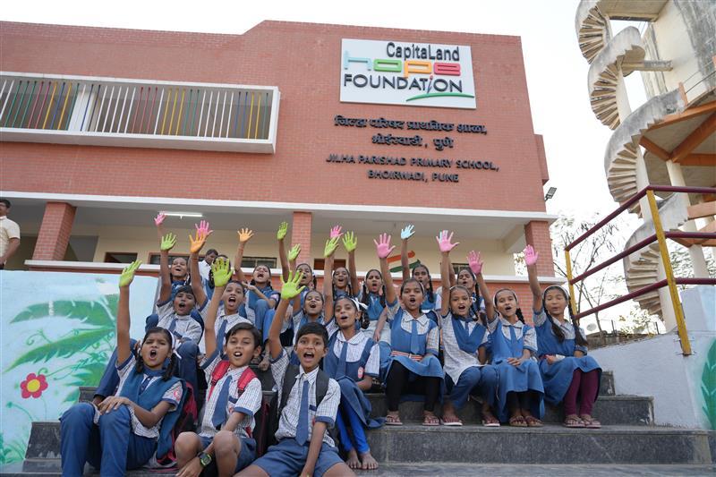 Students sitting on the stairs in front of CapitaLand Hope School, Jilha Parshad Primary School